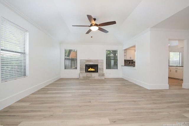 unfurnished living room with lofted ceiling, crown molding, light hardwood / wood-style flooring, ceiling fan, and a fireplace