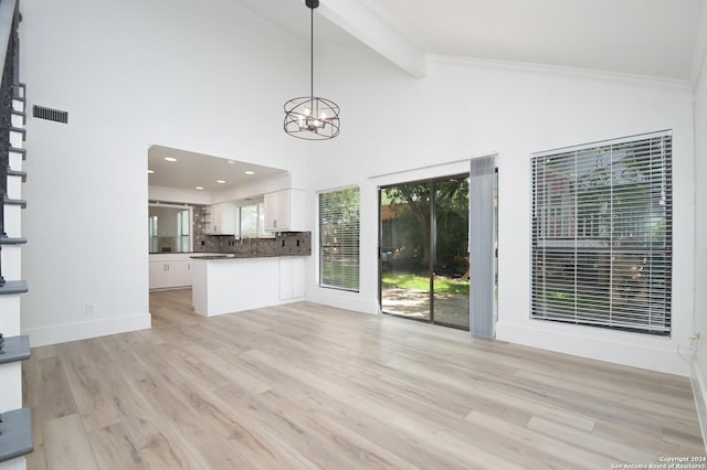 unfurnished living room featuring beamed ceiling, a notable chandelier, light wood-type flooring, and crown molding