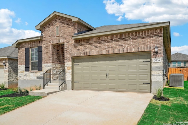 view of front of home featuring a garage and central air condition unit