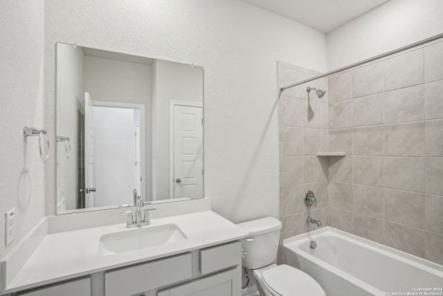 full bathroom with toilet, vanity, and tiled shower / bath