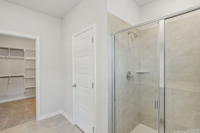 bathroom featuring walk in shower and tile patterned flooring