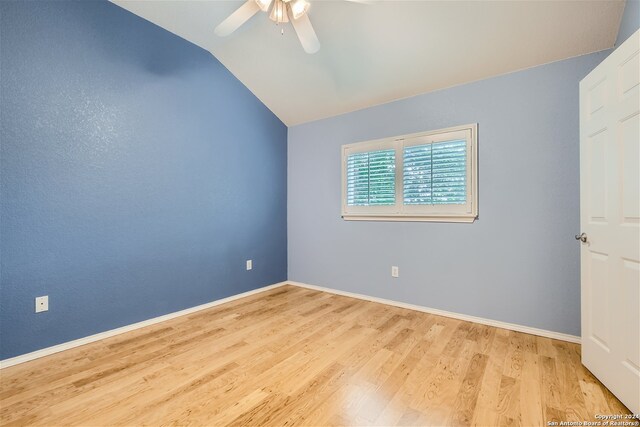 unfurnished room with ceiling fan, lofted ceiling, and light wood-type flooring