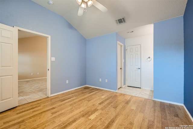 spare room featuring lofted ceiling, ceiling fan, and light hardwood / wood-style flooring