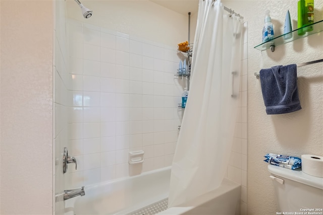 bathroom featuring shower / tub combo with curtain and toilet