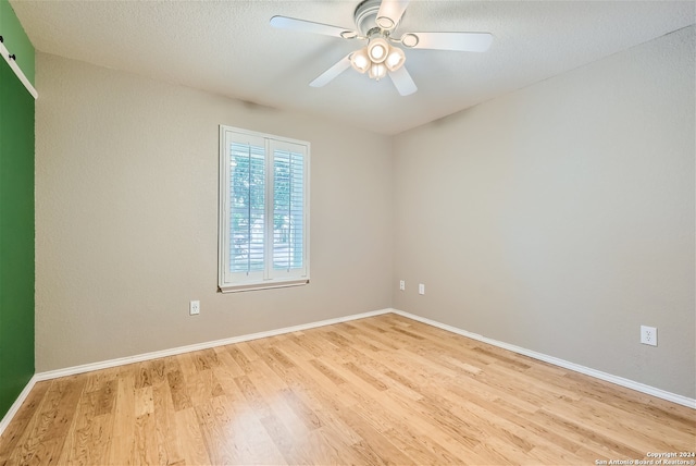 spare room with ceiling fan, a textured ceiling, and light hardwood / wood-style floors