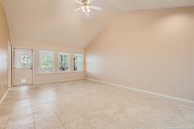 tiled empty room featuring ceiling fan and high vaulted ceiling