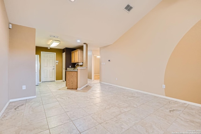 kitchen featuring light stone countertops and white fridge