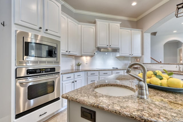 kitchen featuring light stone countertops, white cabinetry, sink, and appliances with stainless steel finishes