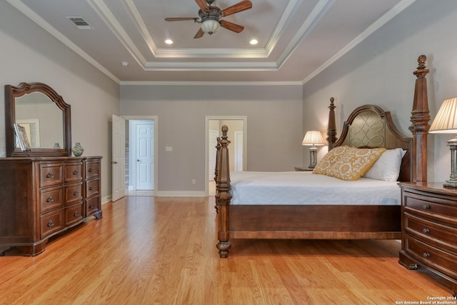 bedroom with ceiling fan, light wood-type flooring, crown molding, and a tray ceiling