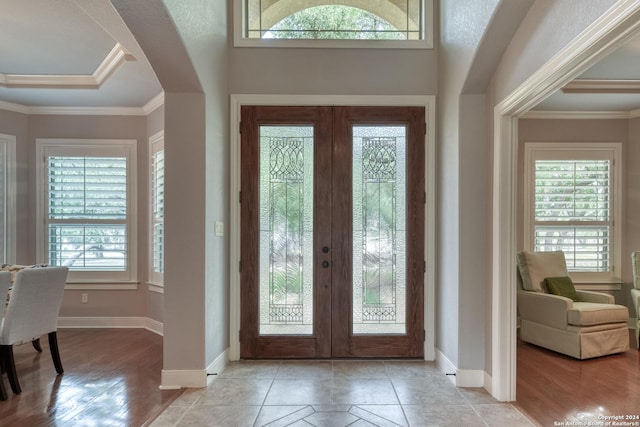 foyer entrance featuring french doors, light tile patterned floors, and ornamental molding