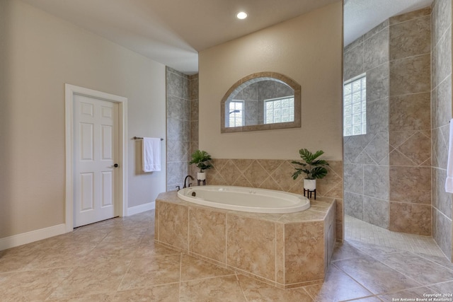 bathroom featuring plenty of natural light and independent shower and bath