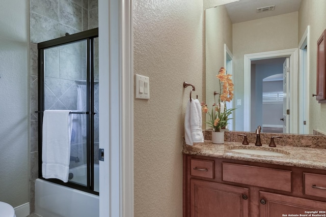 bathroom with vanity and bath / shower combo with glass door