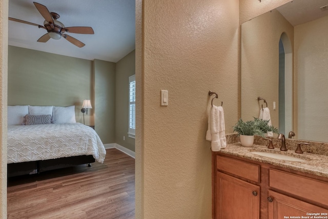 bedroom with ceiling fan, sink, and light hardwood / wood-style floors