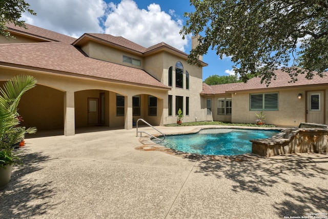 view of swimming pool featuring a jacuzzi and a patio