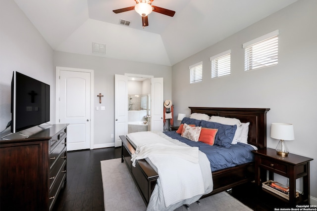 bedroom with ensuite bath, ceiling fan, dark hardwood / wood-style floors, vaulted ceiling, and a tray ceiling