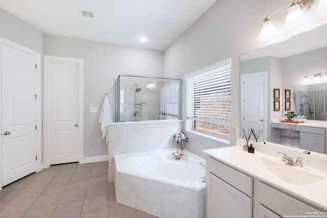 bathroom with vanity, tile patterned flooring, and plus walk in shower