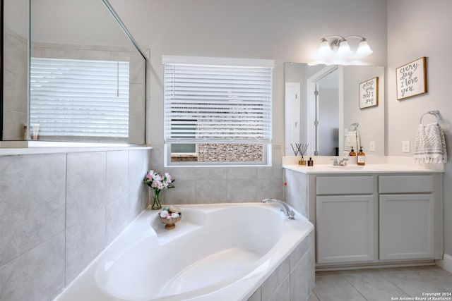 bathroom with tile patterned floors, vanity, and tiled bath