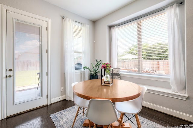 dining space with plenty of natural light and dark wood-type flooring