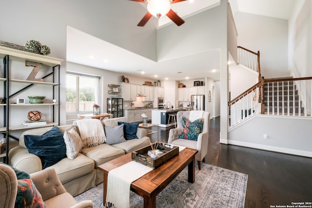 living room with wood-type flooring, a towering ceiling, ceiling fan, and sink