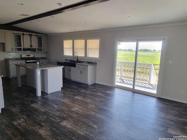 kitchen featuring sink, electric range, vaulted ceiling with beams, dark hardwood / wood-style floors, and a kitchen island