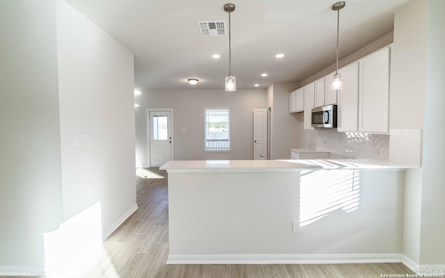 3569 Alto Stratus, New Braunfels, TX 78130 - kitchen featuring light wood-style flooring, stainless steel microwave, white cabinets, baseboards, and visible vents