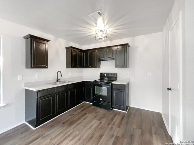 kitchen with black / electric stove, sink, dark brown cabinets, and hardwood / wood-style floors