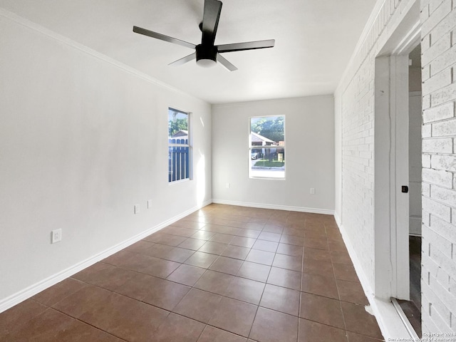 tiled empty room featuring crown molding and ceiling fan