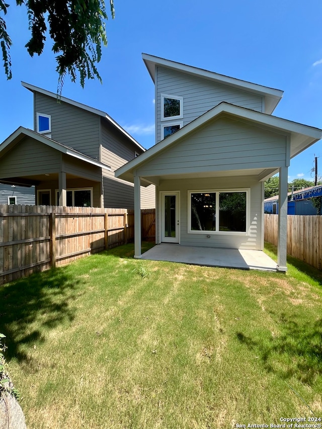 rear view of property with a yard and a patio area