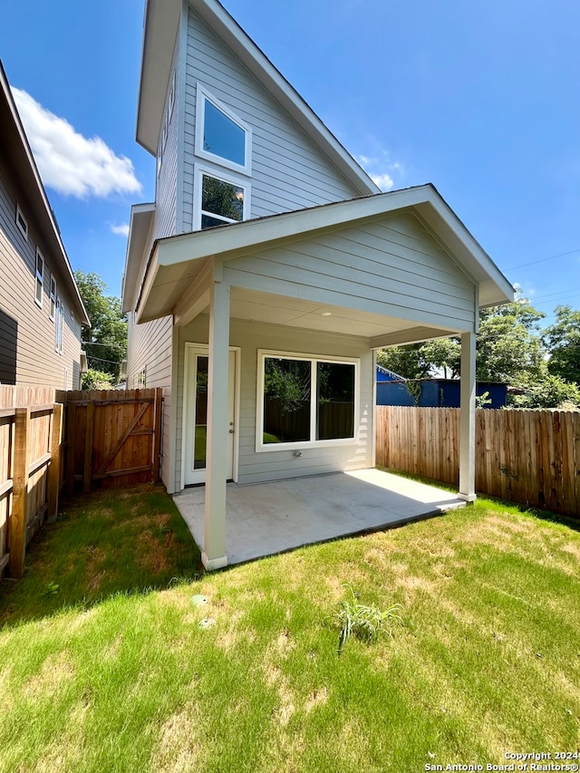 rear view of house featuring a patio area and a lawn