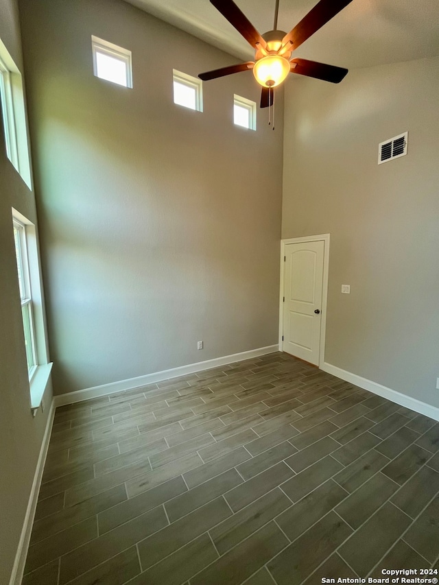 spare room featuring a towering ceiling and ceiling fan