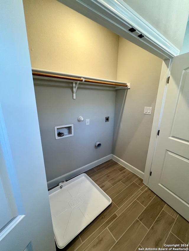 washroom with dark hardwood / wood-style flooring, washer hookup, hookup for an electric dryer, and hookup for a gas dryer