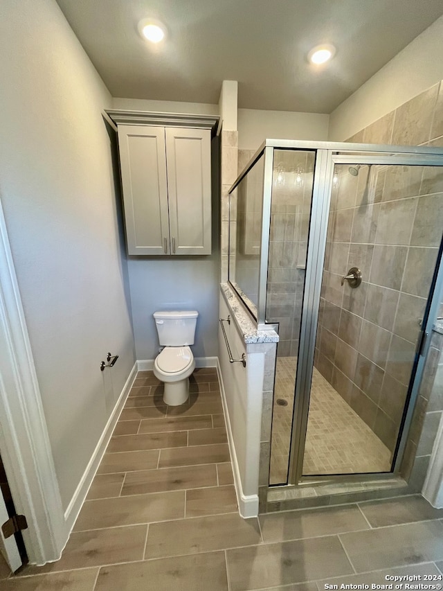 bathroom featuring tile floors, an enclosed shower, and toilet