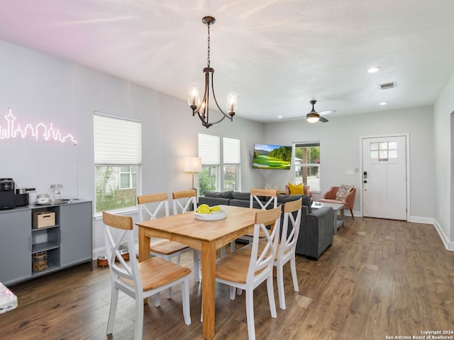 dining room with dark hardwood / wood-style floors and ceiling fan with notable chandelier