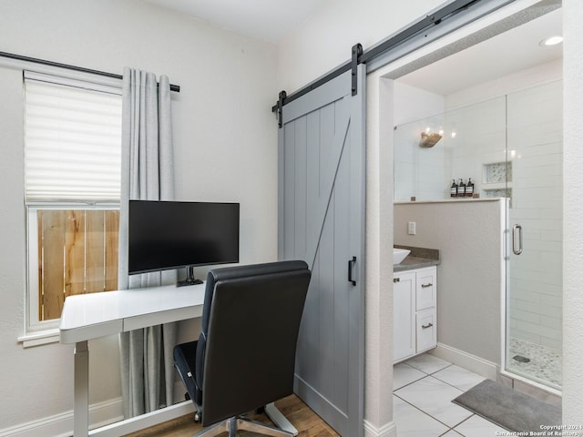 office area with light tile patterned flooring and a barn door