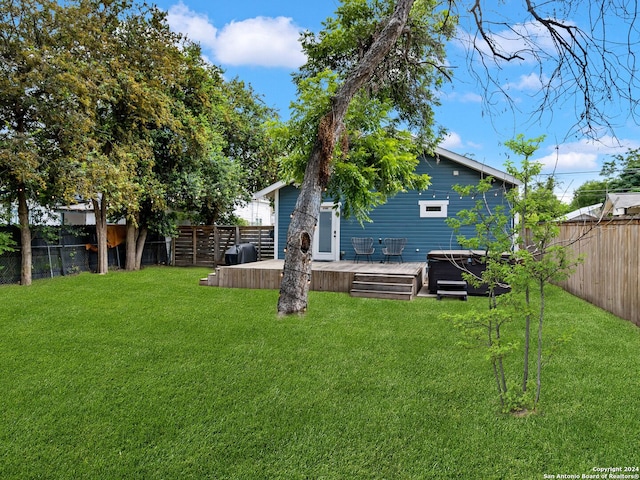 view of yard with a wooden deck and a hot tub