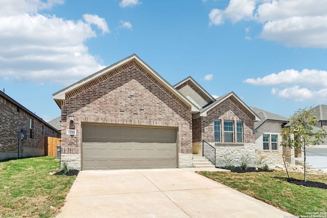 view of front of property featuring brick siding, fence, a garage, driveway, and a front lawn