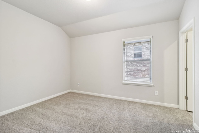 unfurnished bedroom featuring lofted ceiling, carpet, and baseboards