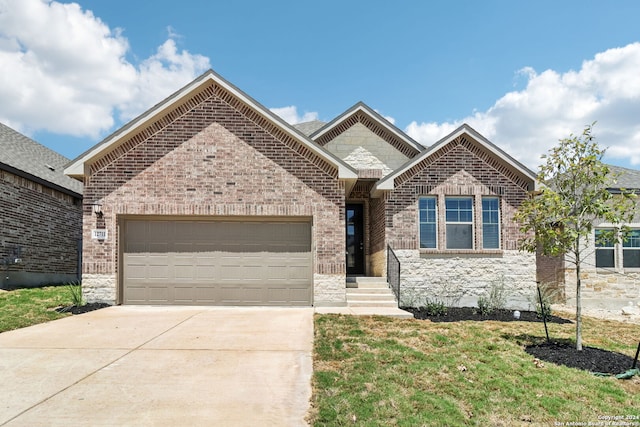 view of front facade with driveway, a front yard, a garage, and brick siding