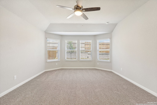 carpeted spare room with a ceiling fan, lofted ceiling, and baseboards