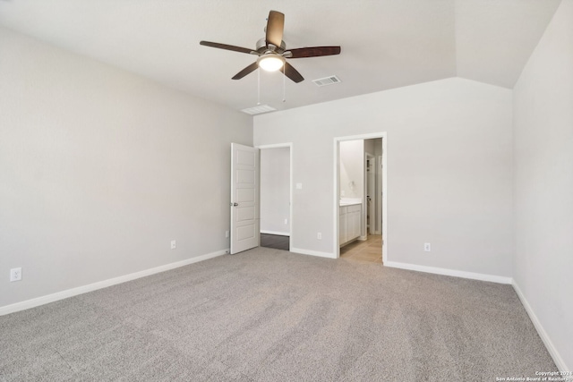 unfurnished bedroom featuring baseboards, visible vents, vaulted ceiling, and light colored carpet