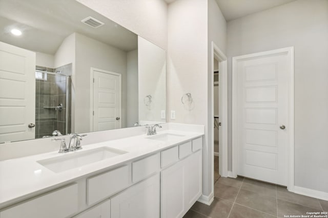 bathroom featuring a stall shower, tile patterned flooring, visible vents, and a sink