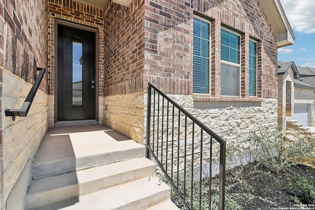 entrance to property featuring brick siding