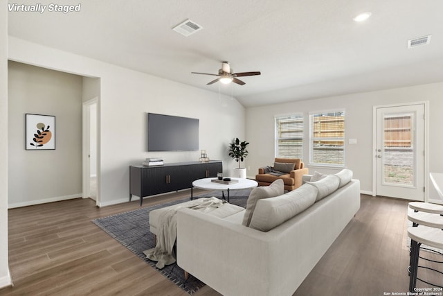 living room featuring ceiling fan, visible vents, and dark wood finished floors