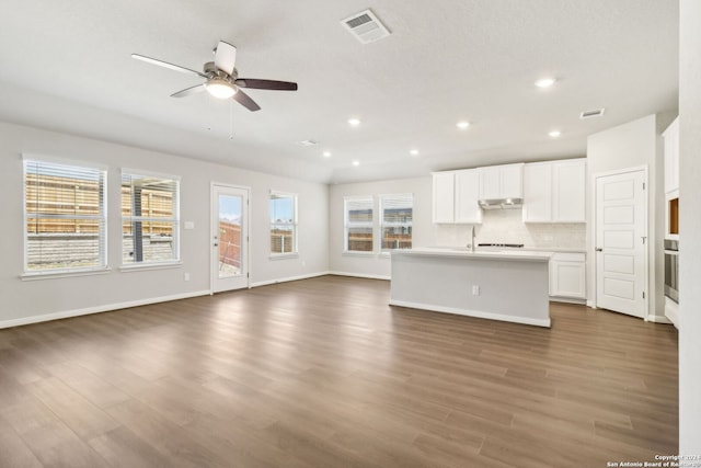 unfurnished living room featuring baseboards, visible vents, dark wood finished floors, a ceiling fan, and recessed lighting