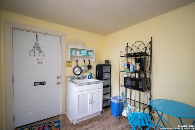 kitchen featuring light hardwood / wood-style floors, white cabinetry, and sink