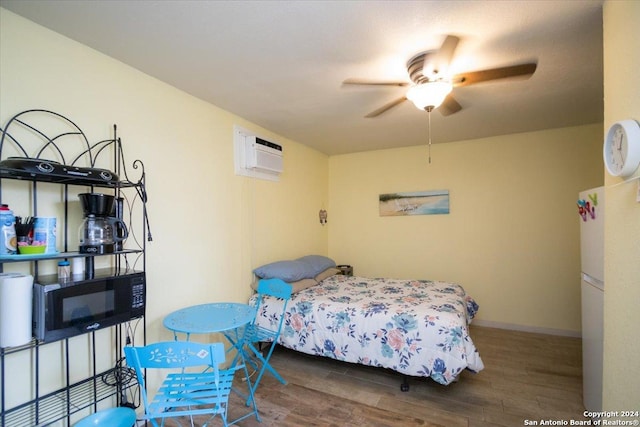 bedroom featuring a wall unit AC, ceiling fan, white fridge, and dark hardwood / wood-style floors