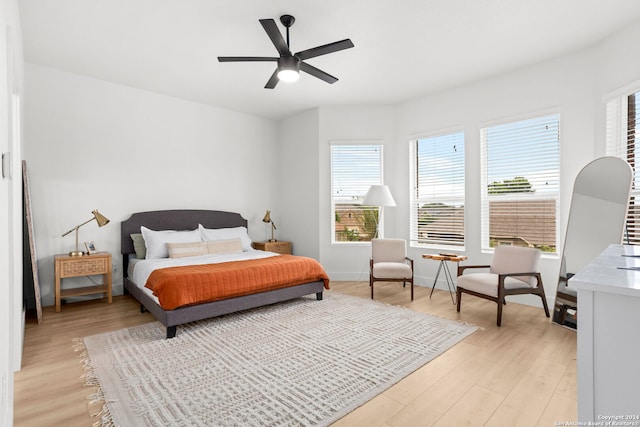 bedroom with multiple windows, light hardwood / wood-style floors, and ceiling fan