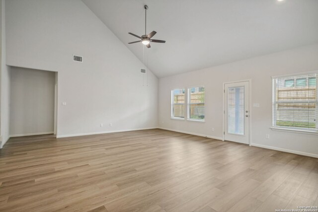 unfurnished living room featuring light wood-type flooring, high vaulted ceiling, and ceiling fan