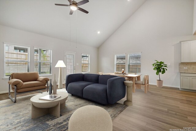 living room featuring high vaulted ceiling, light wood-type flooring, and ceiling fan