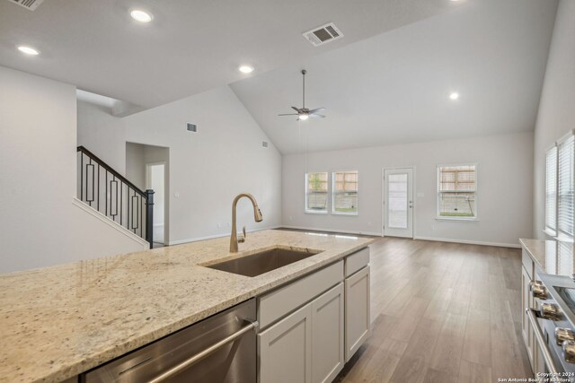 kitchen featuring white cabinets, stainless steel appliances, light stone countertops, ceiling fan, and sink